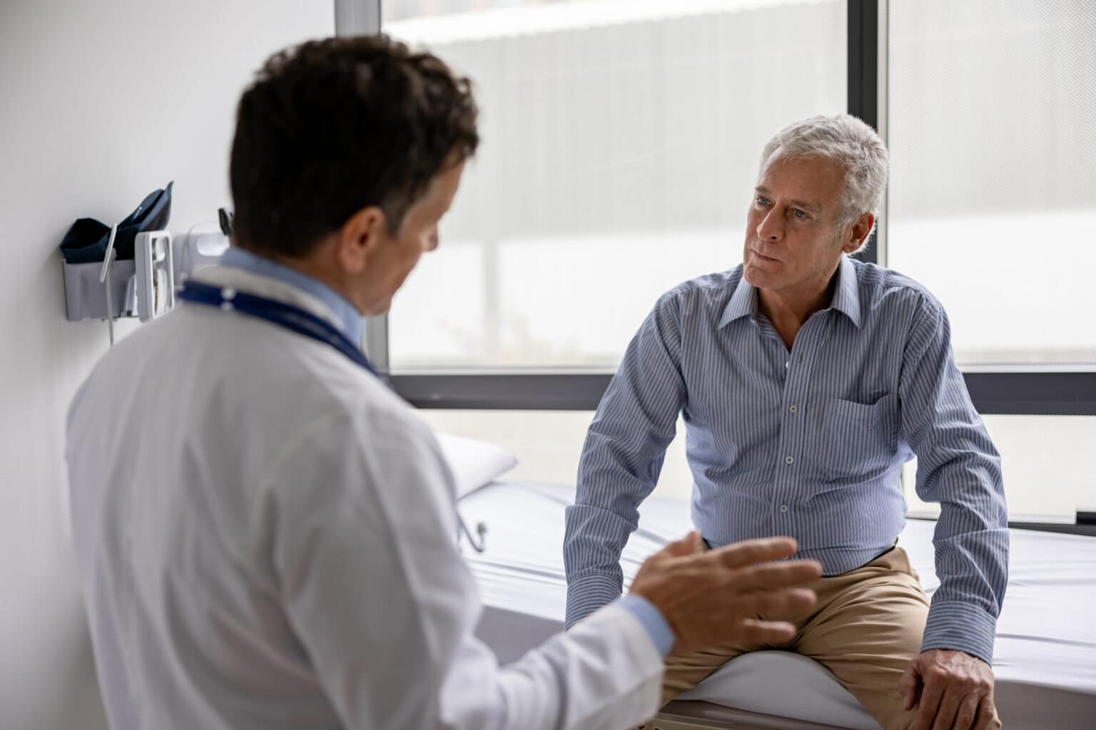 Doctor talking to a patient in clinical medical setting