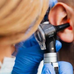 Doctor giving a man an ear exam.