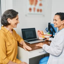 Senior woman consulting with an audiologist about hearing loss.