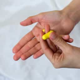 Person holding foam earplugs