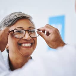 Woman trying on new glasses at the eye doctor