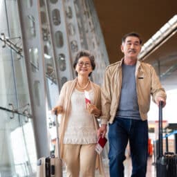 Couple walking through the airport with their suitcases.